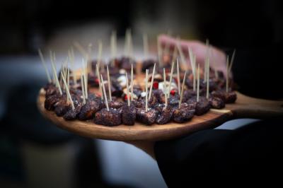 Un couple habillé élégamment, la femme en robe blanche et l'homme en costume, pose dans une pièce lumineuse.