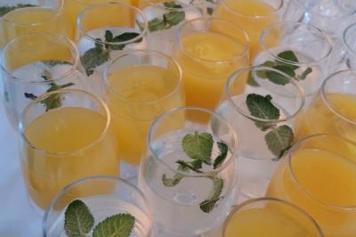 Un couple habillé élégamment, la femme en robe blanche et l'homme en costume, pose dans une pièce lumineuse.