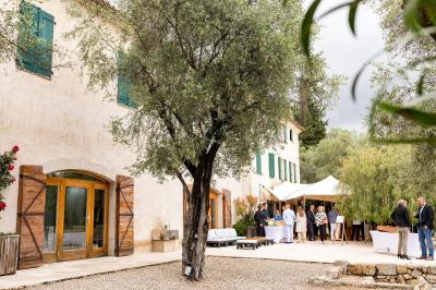 Un couple habillé élégamment, la femme en robe blanche et l'homme en costume, pose dans une pièce lumineuse.