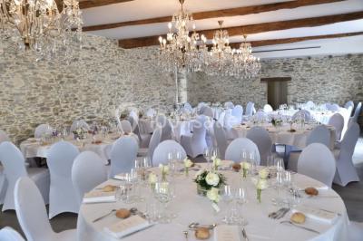 Bouquet de fleurs blanches et roses dans un pichet en terre cuite, posé dans une caisse en bois entourée de verdure.