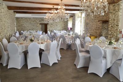 Bouquet de fleurs blanches et roses dans un pichet en terre cuite, posé dans une caisse en bois entourée de verdure.