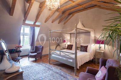 Bouquet de fleurs blanches et roses dans un pichet en terre cuite, posé dans une caisse en bois entourée de verdure.