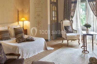 Bouquet de fleurs blanches et roses dans un pichet en terre cuite, posé dans une caisse en bois entourée de verdure.