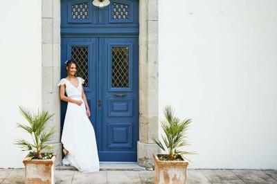 Allée de gravier bordée de rosiers roses en fleurs, entourée de pelouse et d'arbres en arrière-plan.