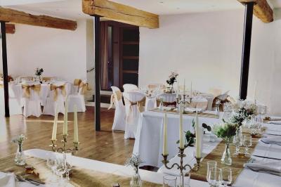 Allée de gravier bordée de rosiers roses en fleurs, entourée de pelouse et d'arbres en arrière-plan.