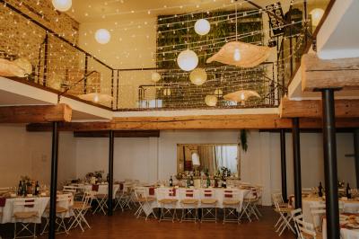 Allée de gravier bordée de rosiers roses en fleurs, entourée de pelouse et d'arbres en arrière-plan.