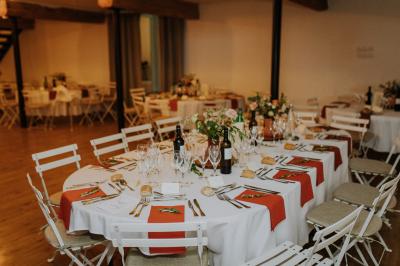 Allée de gravier bordée de rosiers roses en fleurs, entourée de pelouse et d'arbres en arrière-plan.