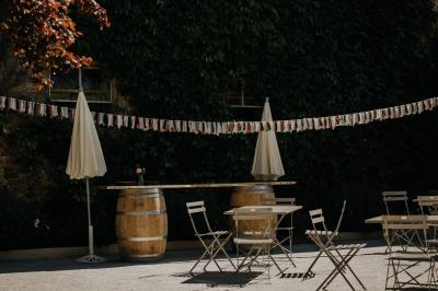 Allée de gravier bordée de rosiers roses en fleurs, entourée de pelouse et d'arbres en arrière-plan.