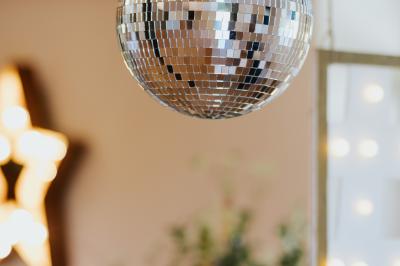 Allée de gravier bordée de rosiers roses en fleurs, entourée de pelouse et d'arbres en arrière-plan.