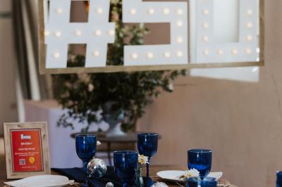 Allée de gravier bordée de rosiers roses en fleurs, entourée de pelouse et d'arbres en arrière-plan.