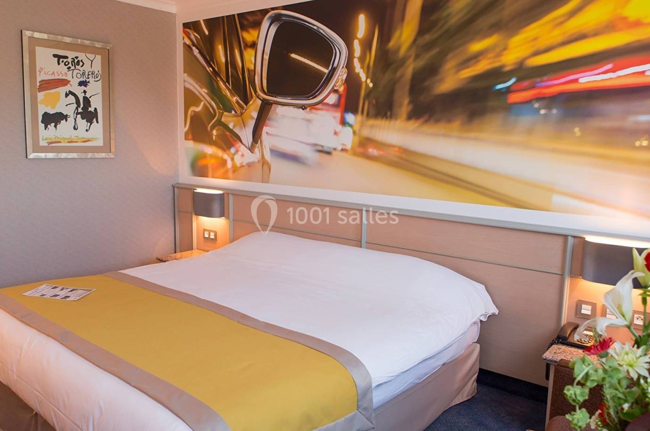 Chambre d'hôtel avec un lit double, une décoration murale dynamique et des lumières tamisées.