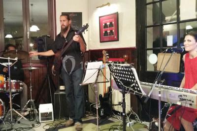 Baguette de pain posée sur un comptoir en bois, avec un four professionnel en arrière-plan dans une cuisine.