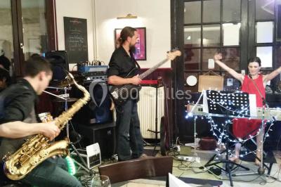 Baguette de pain posée sur un comptoir en bois, avec un four professionnel en arrière-plan dans une cuisine.