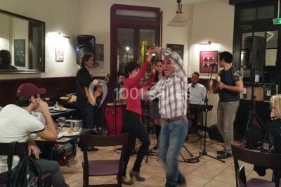 Baguette de pain posée sur un comptoir en bois, avec un four professionnel en arrière-plan dans une cuisine.