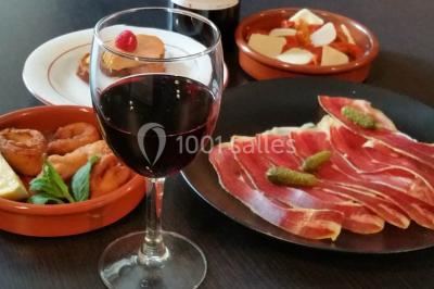 Baguette de pain posée sur un comptoir en bois, avec un four professionnel en arrière-plan dans une cuisine.