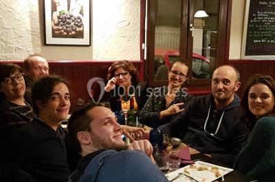 Baguette de pain posée sur un comptoir en bois, avec un four professionnel en arrière-plan dans une cuisine.