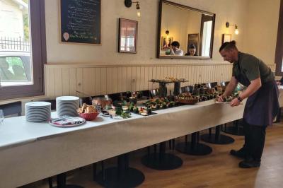 Baguette de pain posée sur un comptoir en bois, avec un four professionnel en arrière-plan dans une cuisine.