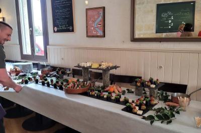 Baguette de pain posée sur un comptoir en bois, avec un four professionnel en arrière-plan dans une cuisine.