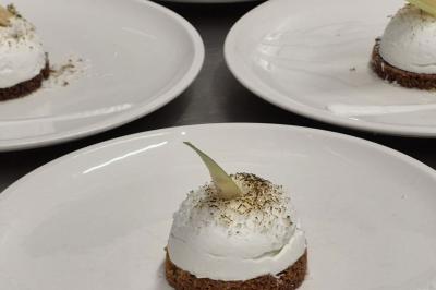 Baguette de pain posée sur un comptoir en bois, avec un four professionnel en arrière-plan dans une cuisine.