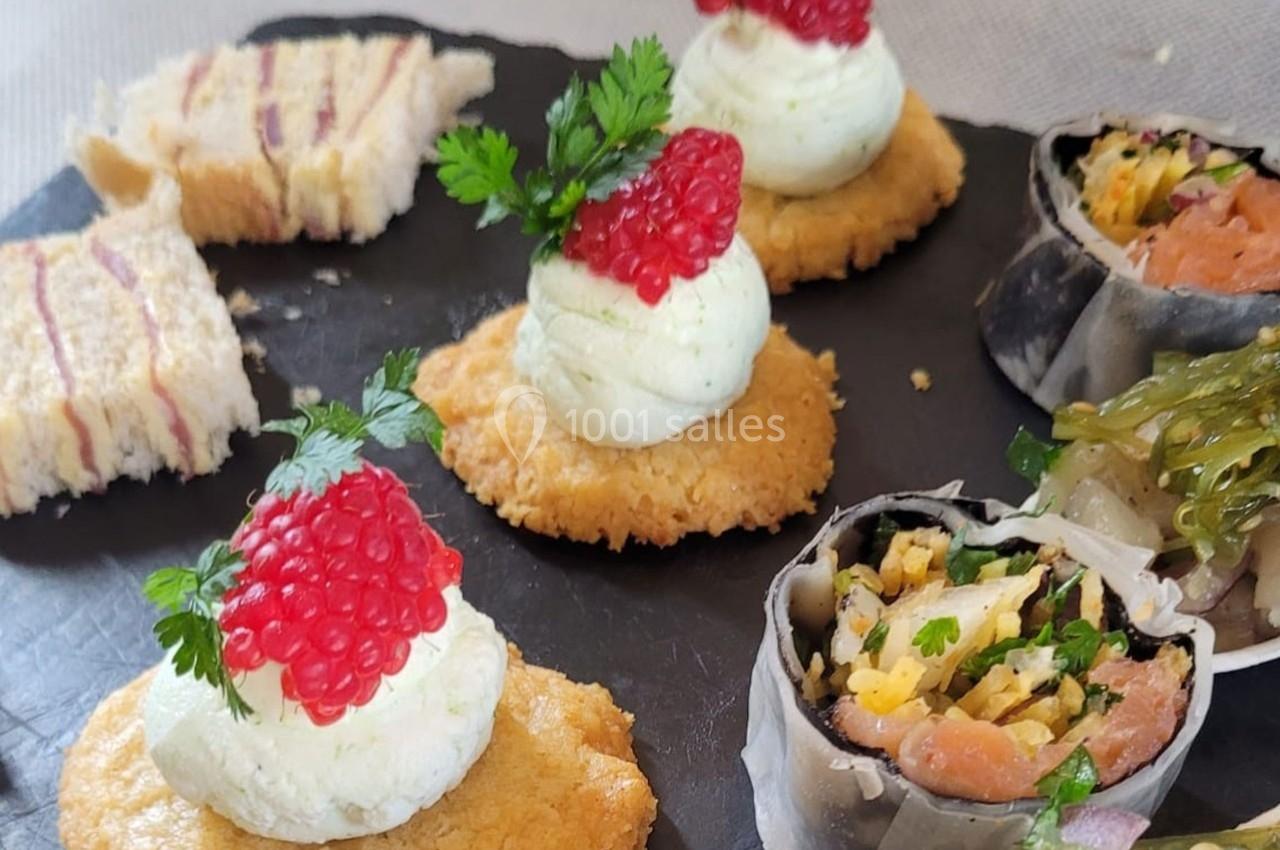 Assortiment de bouchées apéritives comprenant canapés, roulés au saumon et crackers garnis de crème et œufs de poisson.