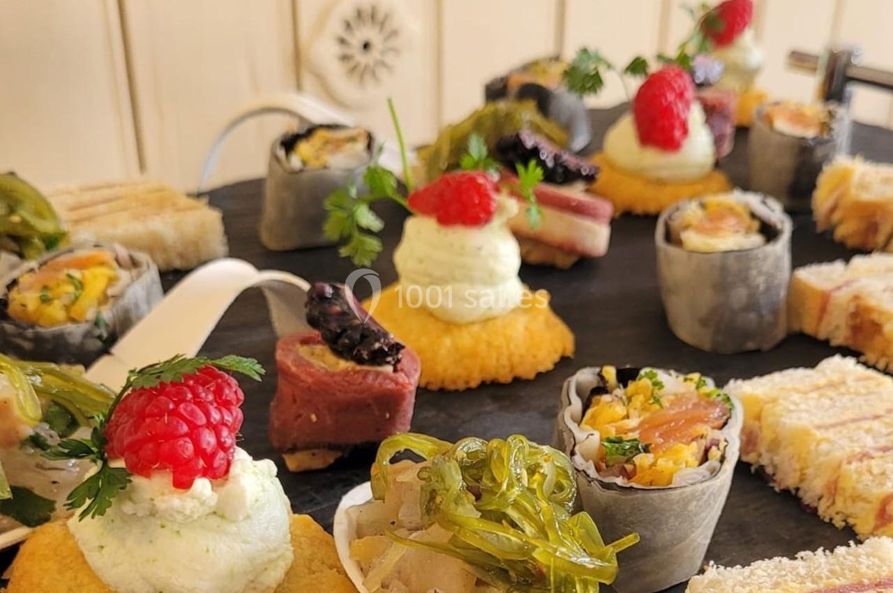 Assortiment de bouchées apéritives variées sur un plateau, incluant fruits, légumes, et garnitures raffinées.