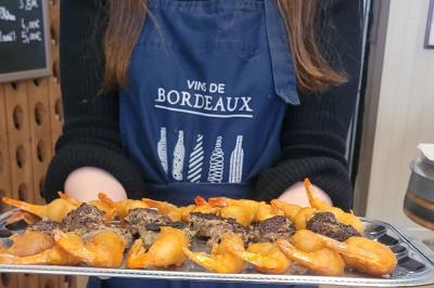Baguette de pain posée sur un comptoir en bois, avec un four professionnel en arrière-plan dans une cuisine.