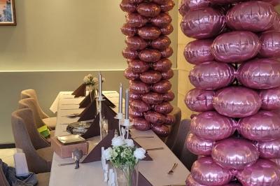 Baguette de pain posée sur un comptoir en bois, avec un four professionnel en arrière-plan dans une cuisine.