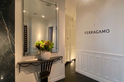 Table ronde en métal noir avec chandelier et chaises, placée sur un balcon avec vue sur une façade d'immeuble haussmannien.
