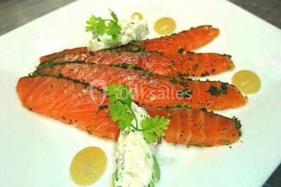 Salle de restaurant lumineuse avec table dressée, grandes fenêtres donnant sur un jardin et murs en briques.
