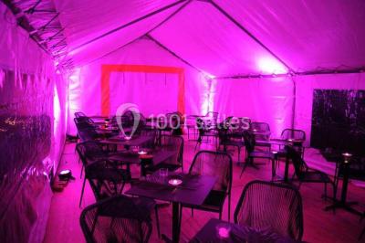 Salle de restaurant lumineuse avec table dressée, grandes fenêtres donnant sur un jardin et murs en briques.