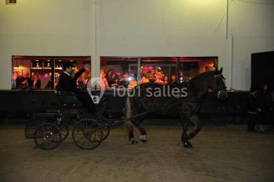 Salle de restaurant lumineuse avec table dressée, grandes fenêtres donnant sur un jardin et murs en briques.