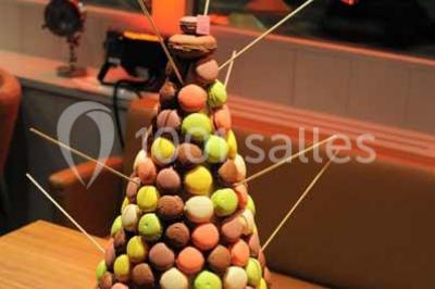 Salle de restaurant lumineuse avec table dressée, grandes fenêtres donnant sur un jardin et murs en briques.