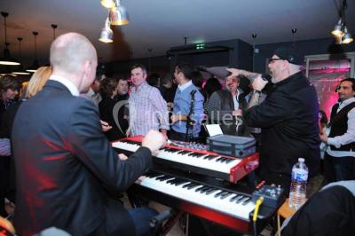 Salle de restaurant lumineuse avec table dressée, grandes fenêtres donnant sur un jardin et murs en briques.