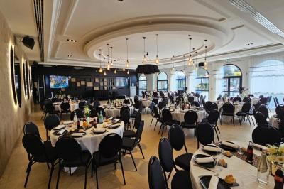 Vue nocturne d'une fête en plein air avec des lumières colorées, une piste de danse et des participants rassemblés.