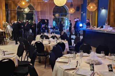 Vue nocturne d'une fête en plein air avec des lumières colorées, une piste de danse et des participants rassemblés.