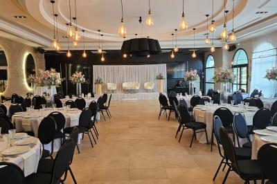 Vue nocturne d'une fête en plein air avec des lumières colorées, une piste de danse et des participants rassemblés.