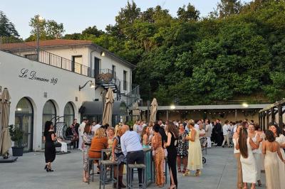 Vue nocturne d'une fête en plein air avec des lumières colorées, une piste de danse et des participants rassemblés.