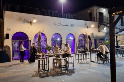 Vue nocturne d'une fête en plein air avec des lumières colorées, une piste de danse et des participants rassemblés.