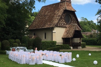 Carte de menu de mariage posée sur une table décorée avec des verres, pétales rouges et nappes blanches.