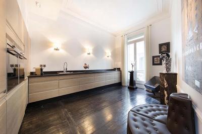 Salle à manger élégante avec table noire ornée, chandeliers, sculpture de panthère et tableau coloré au mur.