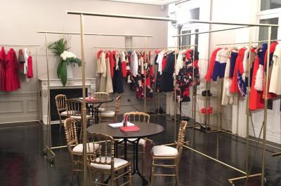 Salle à manger élégante avec table noire ornée, chandeliers, sculpture de panthère et tableau coloré au mur.