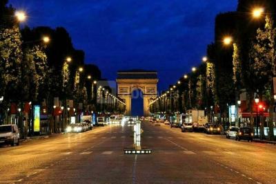 Salle à manger élégante avec table noire ornée, chandeliers, sculpture de panthère et tableau coloré au mur.