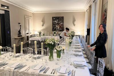 Salle à manger élégante avec table noire ornée, chandeliers, sculpture de panthère et tableau coloré au mur.