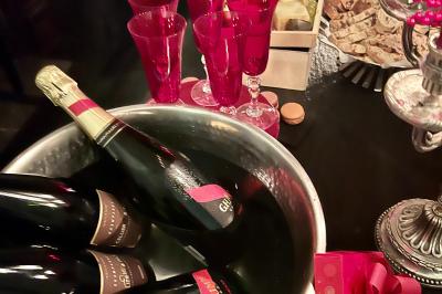 Salle à manger élégante avec table noire ornée, chandeliers, sculpture de panthère et tableau coloré au mur.