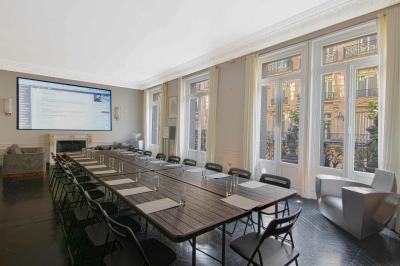 Salle à manger élégante avec table noire ornée, chandeliers, sculpture de panthère et tableau coloré au mur.