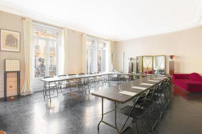 Salle à manger élégante avec table noire ornée, chandeliers, sculpture de panthère et tableau coloré au mur.