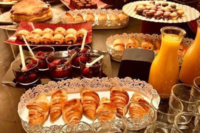 Salle à manger élégante avec table noire ornée, chandeliers, sculpture de panthère et tableau coloré au mur.