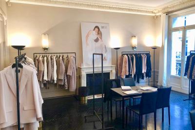 Salle à manger élégante avec table noire ornée, chandeliers, sculpture de panthère et tableau coloré au mur.