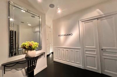 Salle à manger élégante avec table noire ornée, chandeliers, sculpture de panthère et tableau coloré au mur.