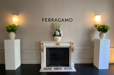 Salle à manger élégante avec table noire ornée, chandeliers, sculpture de panthère et tableau coloré au mur.